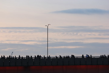 a silhuoette of commuters crossing the London Bridge