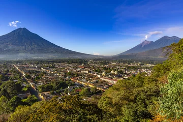 Zelfklevend Fotobehang Guatemala. Antigua. Panoramic view of the city and surrounding volcanoes (from left to right): dormant Agua, smoky Fuego and Acatenango © WitR