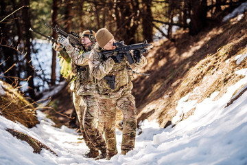 team of special forces weapons in cold forest. Winter warfare and military concept