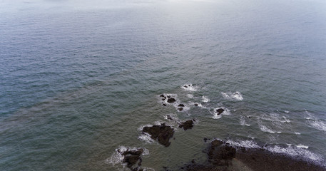 Rocky beach shore. Picture of a rocks surrounded by water.