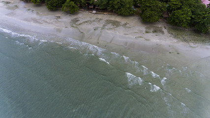 Small waves crashing on the sandy beach.