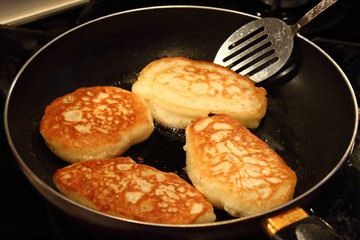Preparation of pancakes in a frying pan on a gas stove. Fritters. Pancakes with milk. Close-up.