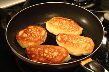 Preparation of pancakes in a frying pan on a gas stove. Pancakes with milk. Close-up.