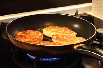 Preparation of pancakes in a frying pan on a gas stove. Pancakes with milk. Close-up.