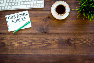 Obraz na płótnie Canvas Business problems. Customer service concept. Words customer service written in manager's notebook on work desk on dark wooden background top view copy space