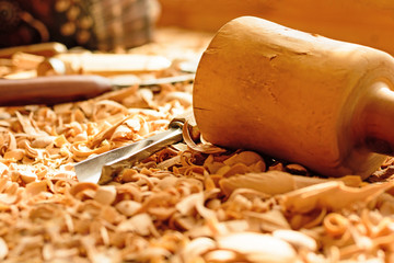 Chisels laid in wooden shavings on the desk. Carving tools lying in the shavings. In a carving...