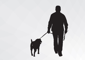 Silhouette of a guy with a dog. The guy goes for a walk with his dog.
