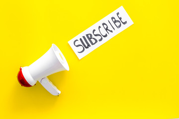 Subscribe template or mockup. Hand lettering subcribe near megaphone on yellow background top view space for text