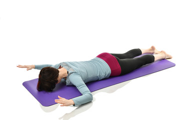 Mother woman exercising doing postnatal workout. Female fitness stretching hands and legs in gym...