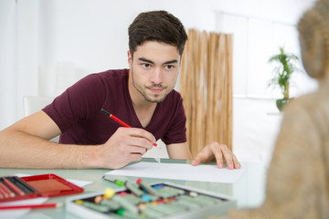 young man drawing pictures in studio
