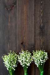 May flowers. Bouqet of lily of the valley flowers on dark wooden background top view copy space