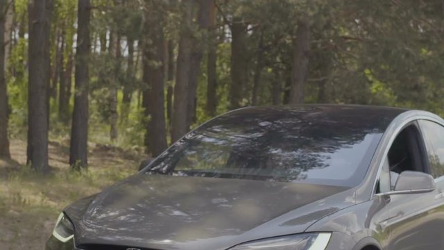 Luxury grey car riding in the forest in slow motion