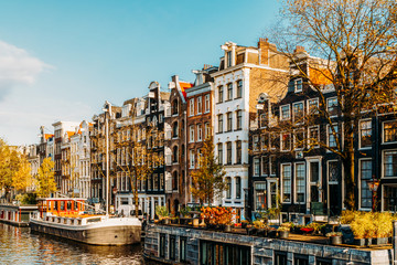 Naklejka premium Piękna architektura holenderskich domów i łodzi mieszkalnych na kanale amsterdamskim jesienią