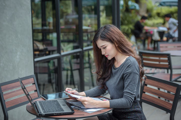 Young attractive Asian business woman sitting on workplace, woman using laptop while sitting at her desk