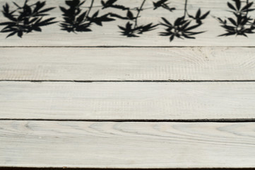 Shadow from hemp plants on a wooden surface