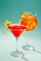Two exotic cocktails of red color in glasses with ice.