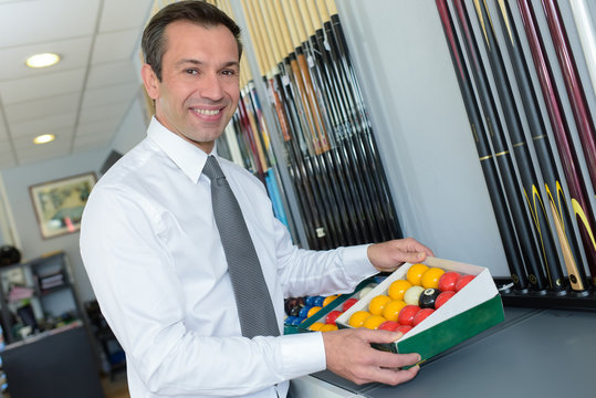 man choosing billiards accesories in a shop