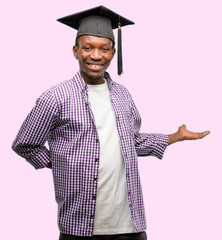 Young african graduate student black man confident and happy with a big natural smile inviting to...