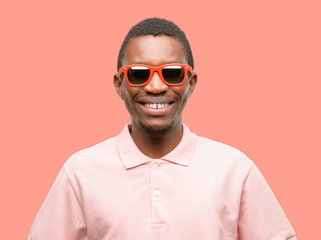 African black man wearing sunglasses confident and happy with a big natural smile laughing