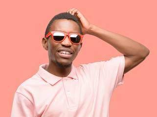 African black man wearing sunglasses pointing away side with finger
