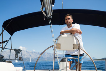 Happy smiling man sailing with his yacht