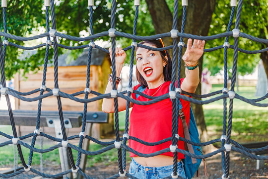 Adult woman is playing on the playground or at rope amusement and adventure park