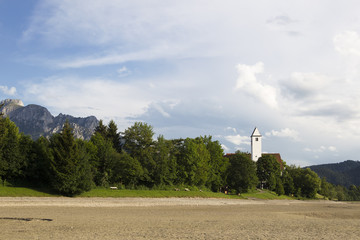 View over the bottom of the dried Forggensee on the Alps in the evening light