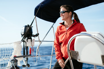 Attractive strong woman sailing with her boat