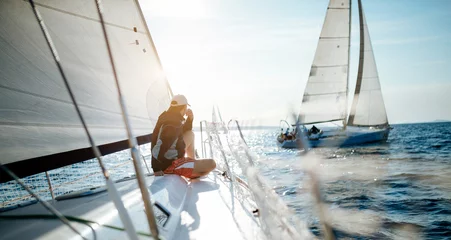 Poster Young handsome man relaxing on his sailboat © NDABCREATIVITY