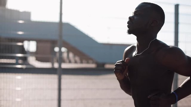 African American male athlete runner running outdoors. Healthy lifestyle - running. Summer time. Man exercising, fitness and sports achievement concepts