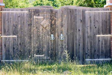 Fototapeta na wymiar Old wooden gate with forged blue handles