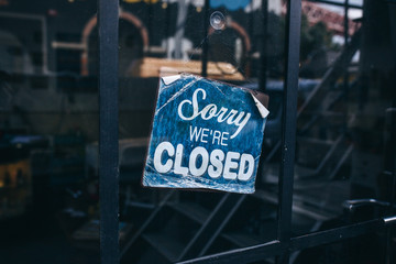 Inscription on a door: Sorry we are closed. Conceptual photo or table on door with information of...