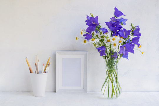 Mockup with a white frame and summer blue flowers