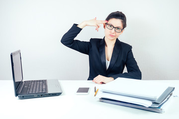 attractive displeased unhappy brunette businesswoman in a stylish business suit working in the...