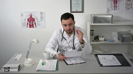 Doctor explaining at camera in medical office