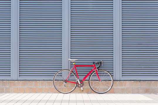 Road red bike stands on the background of a gray wall. Sports concept