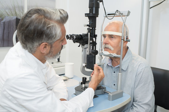 male senior in eye clinic examine eyes