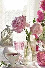 Obraz na płótnie Canvas fruit tea in beautiful porcelain cup and peony flowers