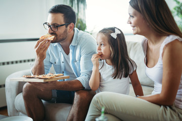 Portrait of happy family sharing pizza at home