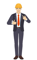 Businessman in construction helmet  showing thumb up and  pointing the finger at himself