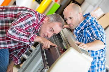 two young technicians repairing printer