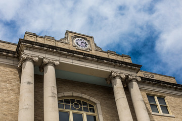 Low angle view of old building with columns framed by blue skies