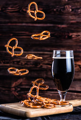 Flying pretzels with a glass of dark beer
