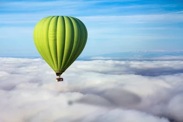 Foto op Aluminium Een eenzame groene heteluchtballon zweeft boven de wolken. Conceptleider, succes, eenzaamheid, overwinning © Nataliia Vyshneva