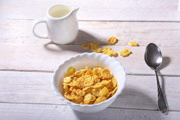 Corn Flakes cereal in a bowl and glass with milk. Morning breakfast.