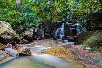Long exposure of a tropical waterfall in middle of a rain forest with water pond beneath it, Koh Phangan, Thailand