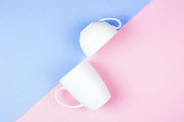 Geometric background with two white cups on colorful paper. Minimal styled design.