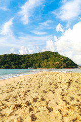 View of Koh Ma island during a sunny day from a tropical Mae Haad sandy beach with sandy path leading towrds the island, Koh Phangan, Thailand