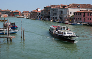 Island Murano in Venice Italy. View on canal with boat and motorboat water. Picturesque landscape. Traditional view of The Venetian canals