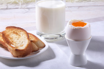 Morning Breakfast set with egg, orange jam on bread toast and milk in glass.